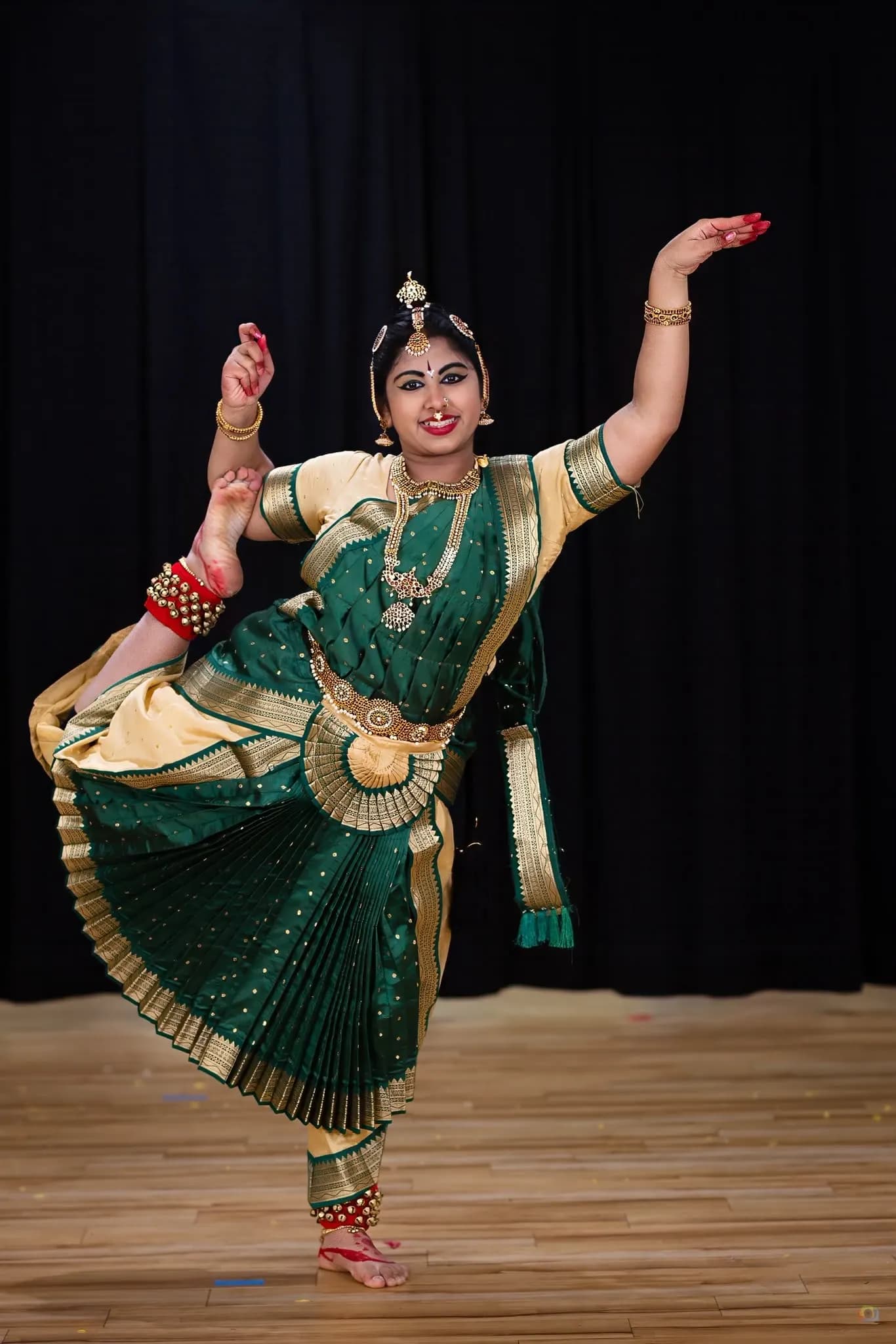 A dancer's hand held in gyan mudra, adorned with bangles